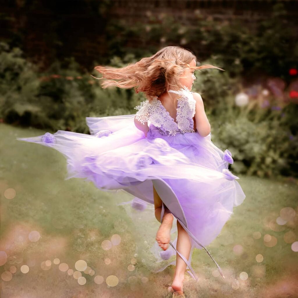 schwungvoller Tanz im Blumengarten eines Mädchens beim Prinzessinnen-Fotoshooting