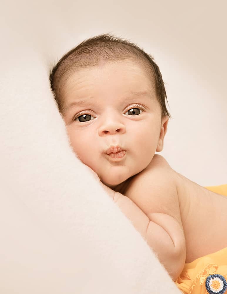 lebendige-neugeborenenfotos-in-wuppertal Baby mit offenen Augen und süßem frechem Gesichtsausdruck beim Fotoshooting für Neugeborene in Wuppertal