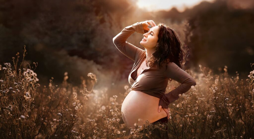 Frau mit sinnlicher Pose mit Babybauch bei ihrem professionellen Schwangerschaftshooting für Naturliebhaber in Wuppertal