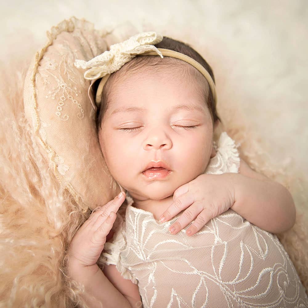 zartes-baby-verschaeft-fotoshooting-neugeborene-in-wuppertal wunderschönes Baby mit sehr langen Wimpern das in einem apricotfarbenen Fell schlummert bei der Neugeborenenfotografie Wuppertal im Fotostudio